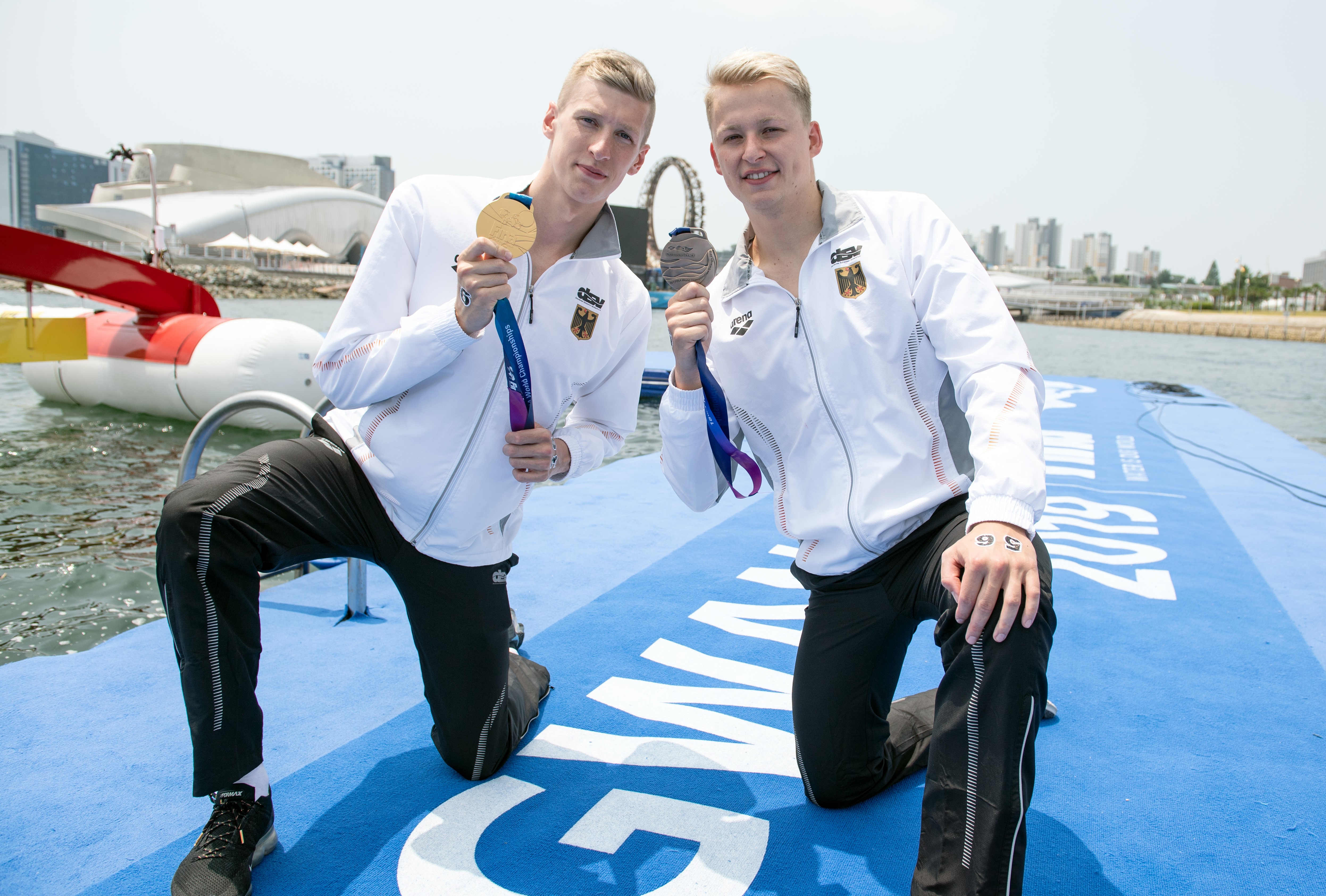 Weltmeister Florian Wellbrock und Rob Muffels strahlen mit ihren WM-Medaillen um die Wette. (Foto: dpa)