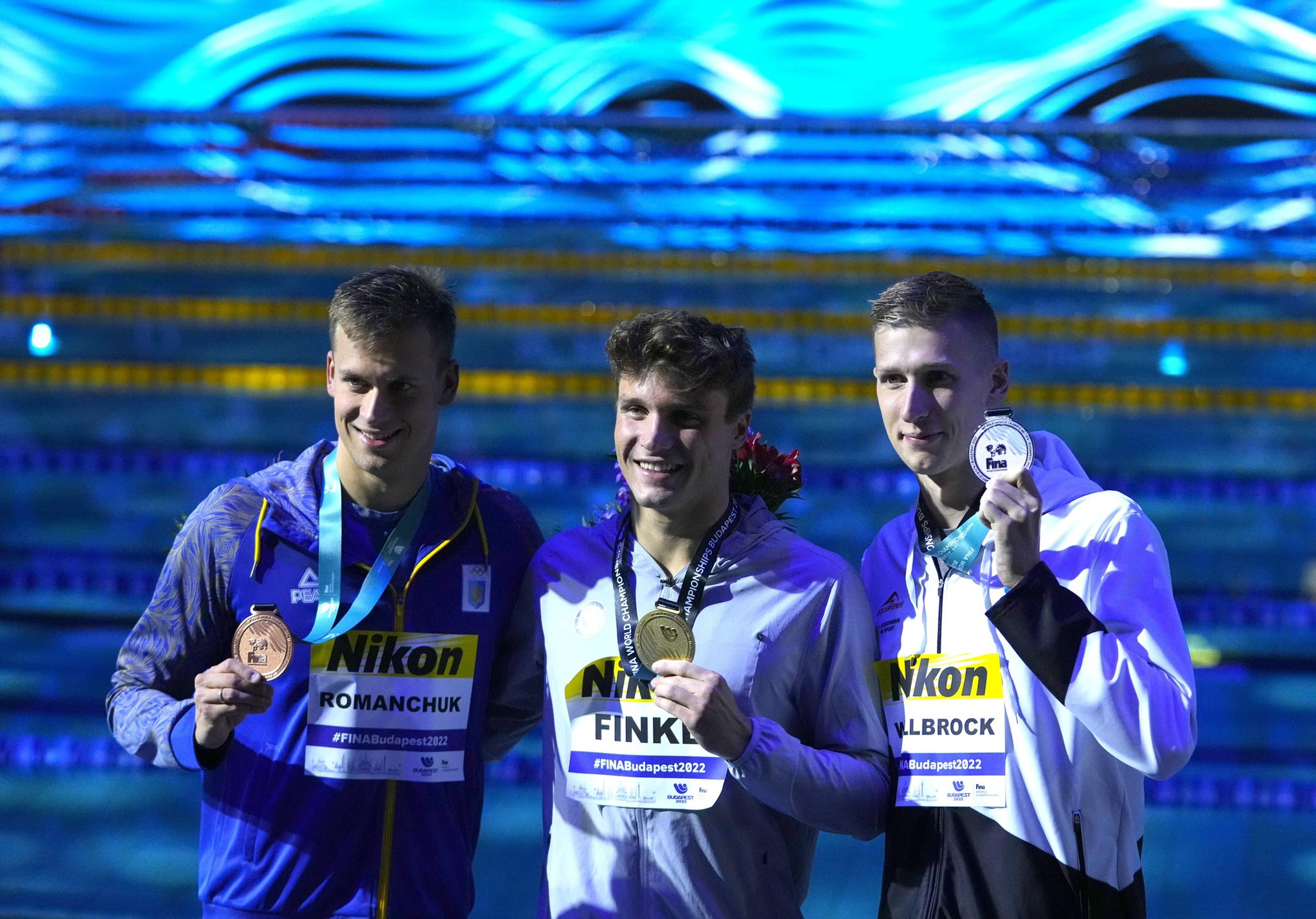 Florian Wellbrock (re.) holt im WM-Finale über 800m Freistil die Silber-Medaille. Gold geht an Bobby Finke (m). Der Ukrainer Michailo Romantschuk (li.) belegt Platz 3. 