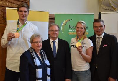Bronzemedaillengewinner Finn Lemke und Olympiasiegerin Julia Lier zeigen stolz ihre Medaillen. LSB-Vizepräsidentin Edda Kaminski, Ministerpräsident Dr. Reiner Haseloff, und Sportminister Holger Stahlknecht freuen sich mit ihnen.