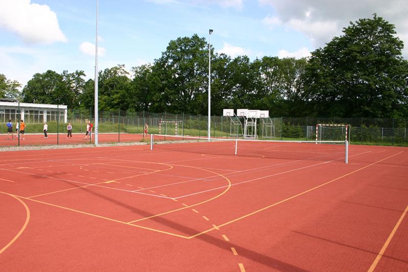 Tartanplatz mit Linierung für Basketball, Handball, Tennis und Volleyball.
